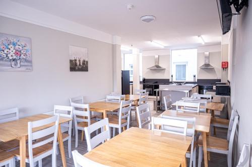 a dining room with wooden tables and white chairs at Avondale House Mulranny in Mulranny