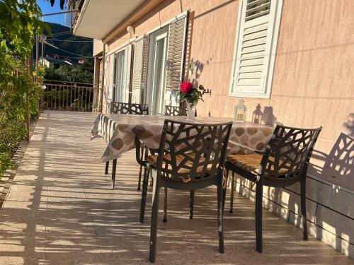 a table and chairs on the porch of a house at Apartment Ciba in Komiža