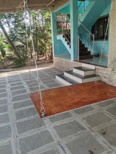 a porch with a swing in front of a house at Shreya Cottage, Vaishet-Alibag in Vaishet