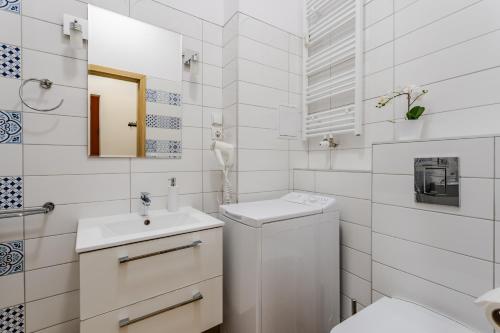 biała łazienka z umywalką i toaletą w obiekcie Apartament Fair Targi Dworzec POZNAŃ Gąsiorowskich w Poznaniu