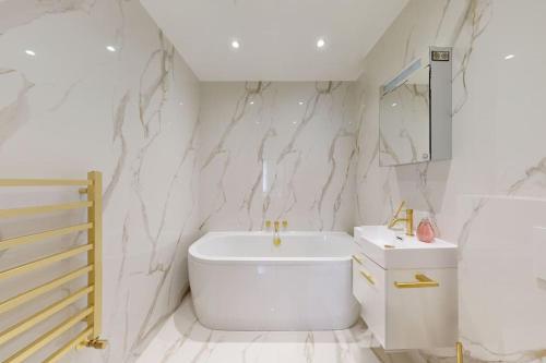 Amazing Newly Refurbished Mews House in W1 في لندن: حمام ابيض مع مرحاض ومغسلة
