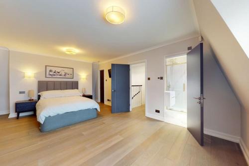 ein Schlafzimmer mit einem Bett und einer offenen Tür in der Unterkunft Amazing Newly Refurbished Mews House in W1 in London