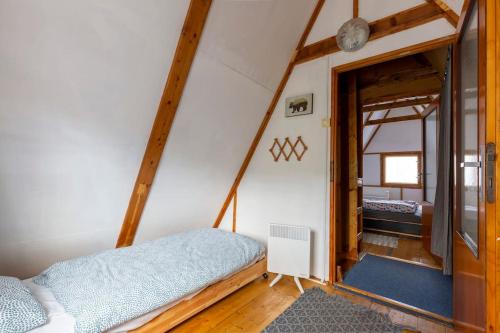 um quarto com uma cama e um quarto com uma porta em Bringás Vityilló - Nagymaros em Nagymaros