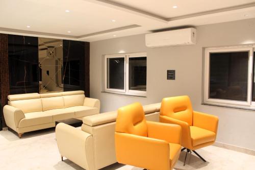 a living room with a couch and chairs at The Vantage Inn, near US Consulate Gachibowli Hyderabad in Hyderabad