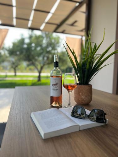a bottle of wine and a glass on a table at Naiades Villas Lilea in Ladharió