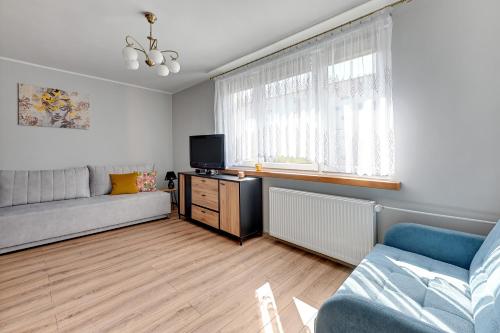 sala de estar con sofá y TV en Wejhera by Comfort Apartments, en Jelitkowo