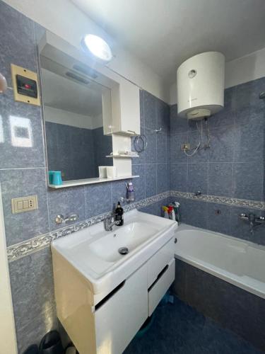 ein Badezimmer mit einem weißen Waschbecken und einer Badewanne in der Unterkunft Private House Shkoder in Shkodra