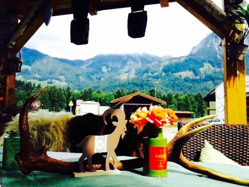 a table with a vase of flowers and a statue at Steinbock Bed & Breakfast in Fischen