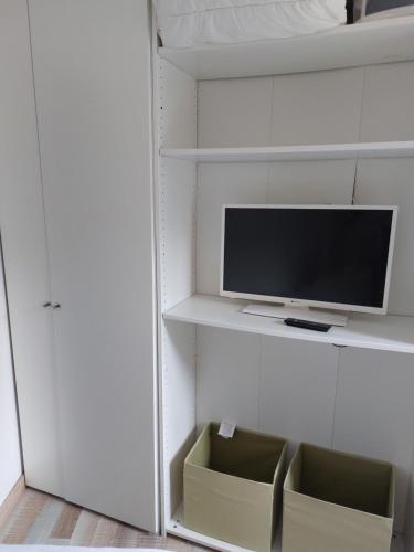 a living room with a tv on a shelf at Home St. Germain in Trouville-sur-Mer