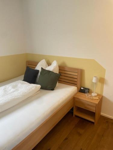 ein Schlafzimmer mit einem Bett mit Kissen und einem Nachttisch in der Unterkunft 1 Zimmer Appartement nahe Gmunden Top2 in Pinsdorf