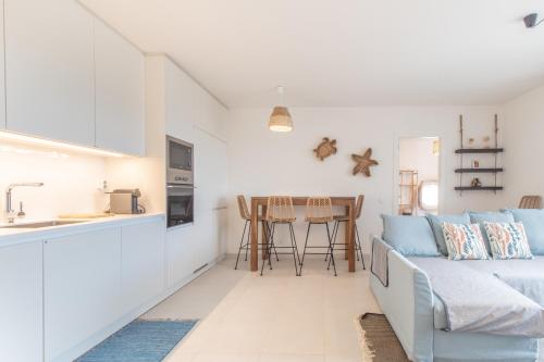 a living room with a couch and a kitchen at Casas do Forte Remos 5pax by Portugal hideaway in Cabanas de Tavira