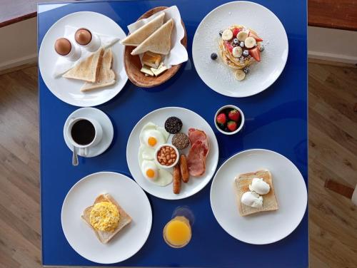 una mesa azul cubierta con platos de desayuno en Killarney View House B&B, en Killarney