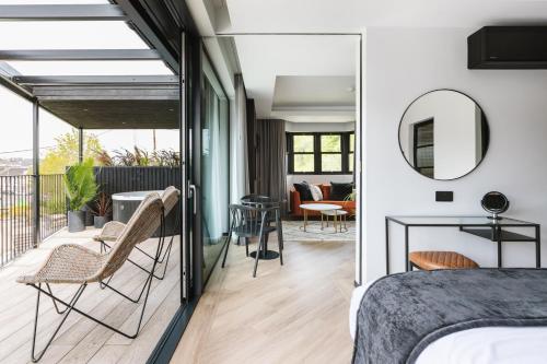 ein Schlafzimmer mit einem Balkon mit einem Bett und einem Spiegel in der Unterkunft The Cliffe at the Quay in Donegal