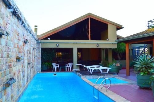 a house with a swimming pool in front of a house at Aspen Hotel & Apart in Asunción
