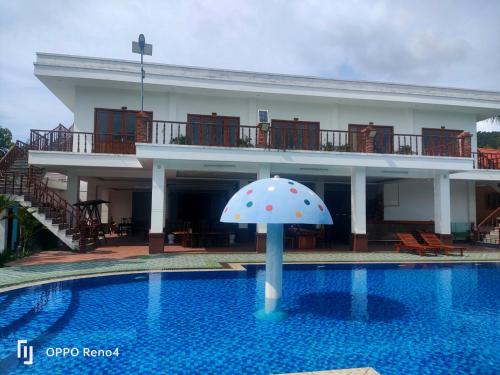a house with an umbrella in the swimming pool at Serene Resort Phú Quốc in Phu Quoc