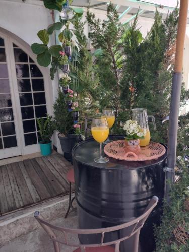 uma mesa com dois copos de vinho num barril em Pousada Rosa de Saron em Holambra