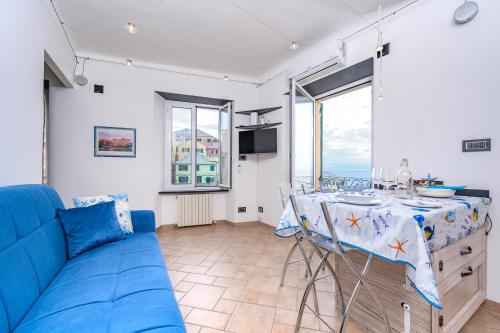 Casa Iole a Boccadasse - Genovainrelax في جينوا: غرفة معيشة مع أريكة زرقاء وطاولة