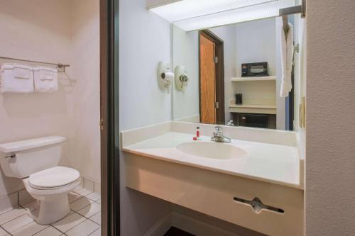 La salle de bains est pourvue d'un lavabo, de toilettes et d'un miroir. dans l'établissement Super 8 by Wyndham Garland North Dallas Area, à Garland