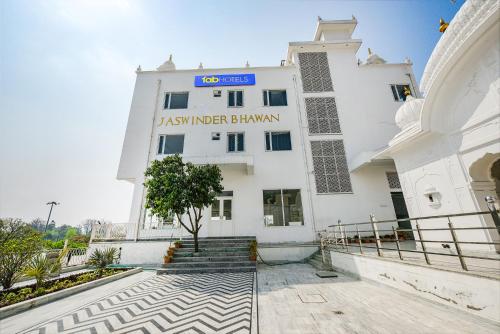 a large white building with a sign on it at FabHotel Jaswinder Bhawan in Haridwār