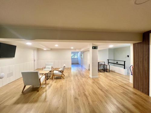 a living room with a table and chairs and a television at Hostal Mindanao in Salamanca