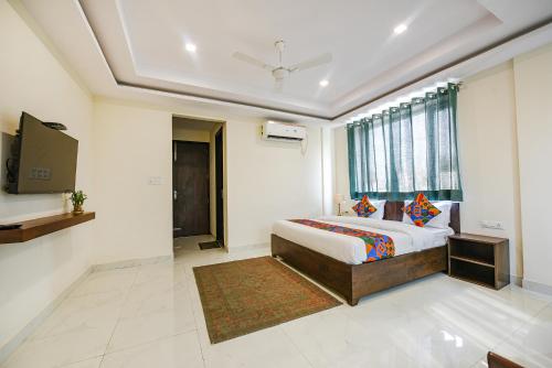 a hotel room with a bed and a window at FabHotel Jaswinder Bhawan in Haridwār