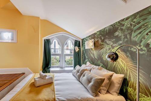 een bed in een kamer met een grote muurschildering bij Old School Cottage in Sandgate