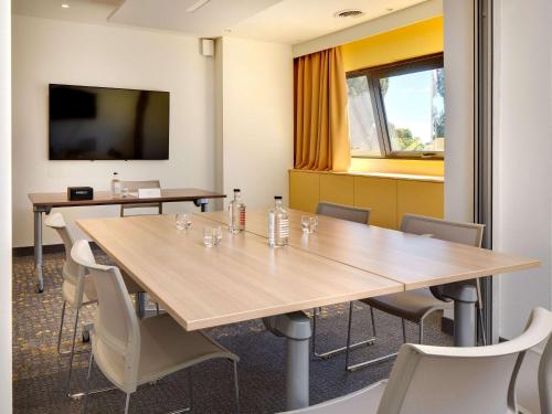 Sala de conferencias con mesas y sillas y TV de pantalla plana en Mercure Montpellier Centre Comédie, en Montpellier