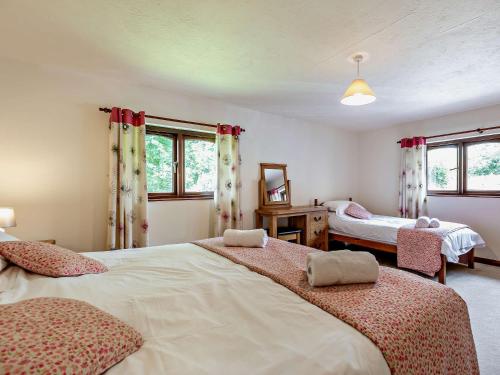 1 dormitorio con 2 camas y 2 ventanas en 4 Bed in Bude LAMER, en Merryfield