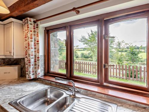 uma cozinha com um lavatório e duas janelas em 4 Bed in Bude LAMER em Merryfield