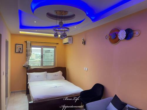 - une chambre avec un lit et un plafond bleu dans l'établissement BOSSLIFE APARTMENTS-TERMINUS SAINT MICHEL DERRIERE Barcelone Hôtel, à Douala