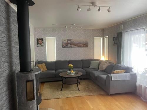 salon z kanapą i kominkiem w obiekcie Stosjöcups Boende w mieście Östersund