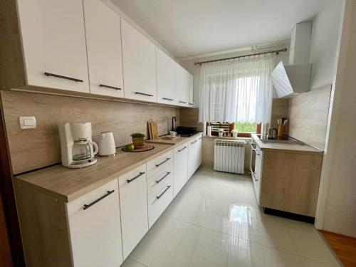 a kitchen with white cabinets and a white floor at Apartment Adri in Rovinj