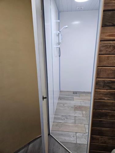 a bathroom with a glass door and a tile floor at Trailor Escape GLAMPING POD - our converted horse box at Nelson Park Riding Centre - Birchington, Margte, Thanet, Ramsgate, Broadstairs, Sandwich, Herne Bay in Birchington