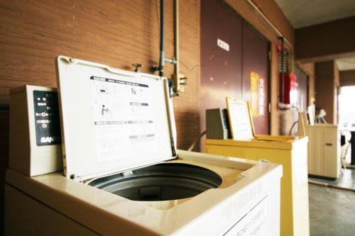 a box with a laptop sitting on top of a washing machine at ホテルパブリック21 in Yokkaichi