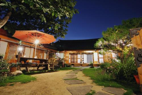 a house with a picnic table and an umbrella at Hanok Madang in Jeonju