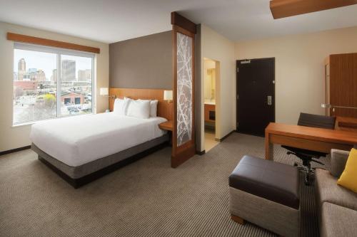 a large hotel room with a bed and a desk at Hyatt Place Oklahoma City Bricktown in Oklahoma City