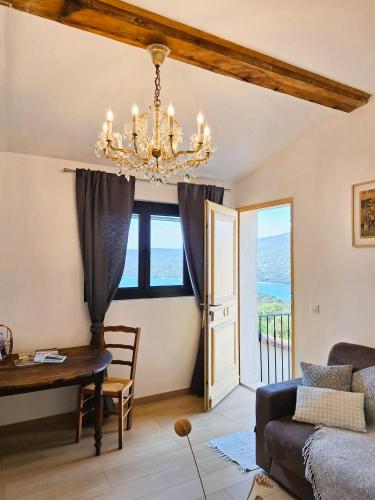 a living room with a chandelier and a table at U Castellu, l' hôtel particulier in Propriano