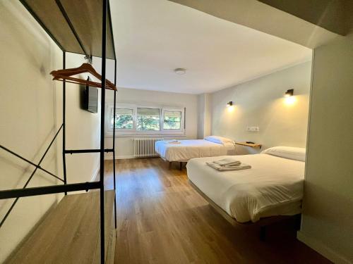 una camera d'albergo con due letti e una finestra di Hostal Mindanao a Salamanca