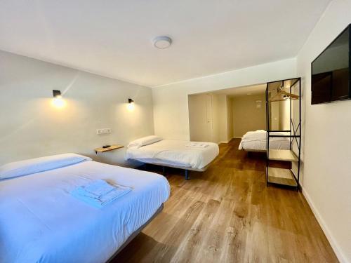 a hotel room with two beds and a mirror at Hostal Mindanao in Salamanca