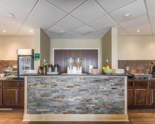 a kitchen with a counter with a stone wall at Quality Inn in Moncton