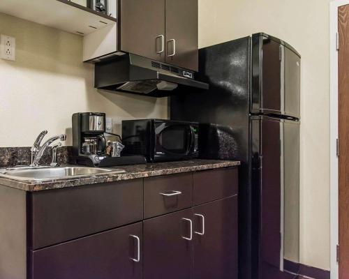 a kitchen with a sink and a refrigerator at Quality Inn in Moncton