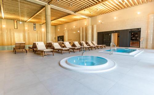 a large room with a hot tub in the middle at Instytut Zdrowia Sofra FIT & SPA in Mielno