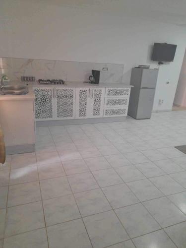 Pokój z kuchnią i podłogą wyłożoną kafelkami w obiekcie Appartement yakine w mieście Midun