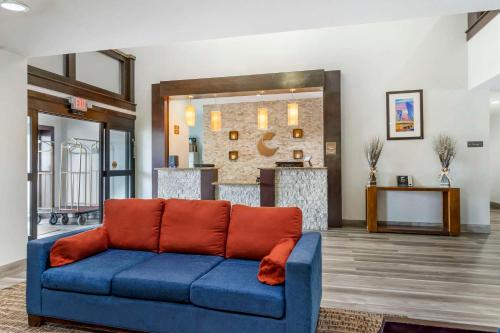 uma sala de estar com um sofá azul com almofadas laranja em Comfort Inn & Suites FM1960-Champions em Houston