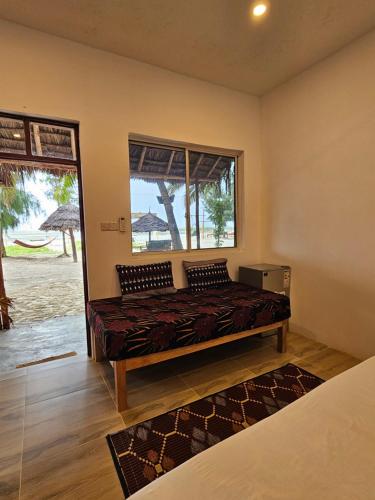 a bedroom with a bed and a window at Zanzibar Gem Beach Bungalows in Bwejuu