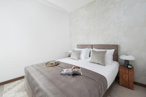 a bedroom with a bed with a book on it at Sol Marina Resort Wyspa Sobieszewska II - LoftAffair Collection in Wiślinka
