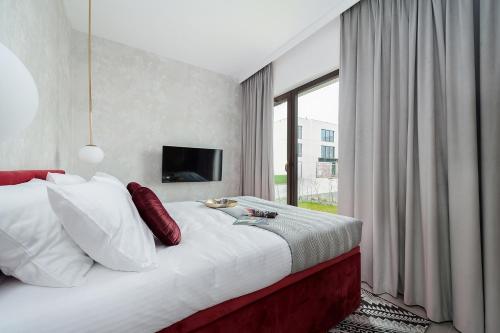 a bedroom with a large bed and a large window at Sol Marina Resort Wyspa Sobieszewska II - LoftAffair Collection in Wiślinka