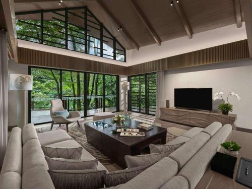 a living room with a large couch and a tv at Pullman Ciawi Vimala Hills Resort in Bogor