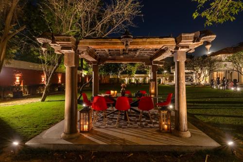 einen Pavillon mit einem Tisch und Stühlen darunter in der Nacht in der Unterkunft Elivaas Oasis Luxury 6BHK with Pvt Pool, Sainik Farm New Delhi in Neu-Delhi