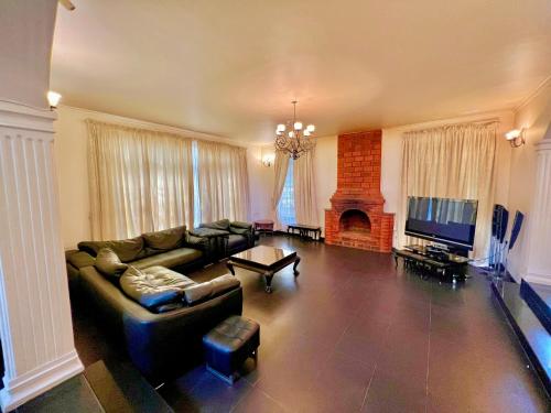 sala de estar con sofá y chimenea en Wenzi Luxury Home, en Arusha